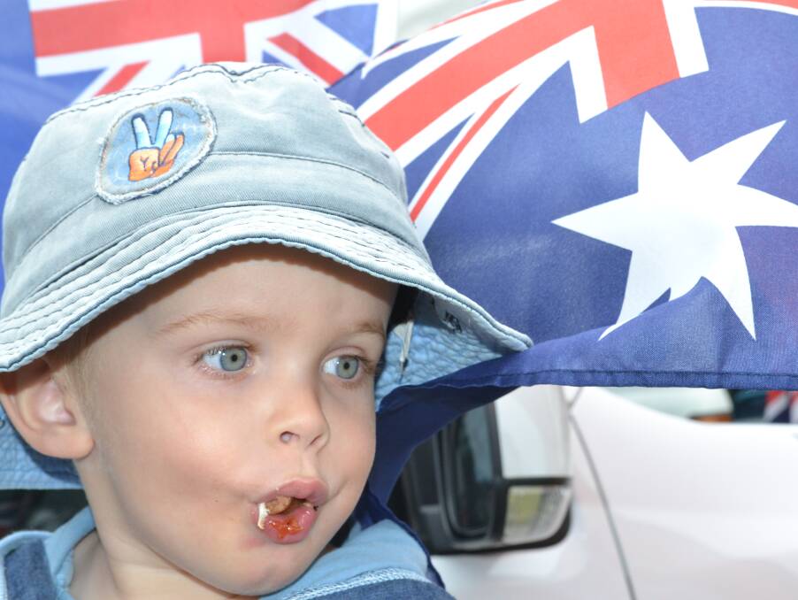 SNAGS: Braxton Brayne with a mouth full of sausage and an Australia flag was the picture of the Australia Day celebrations at the 2015 event.