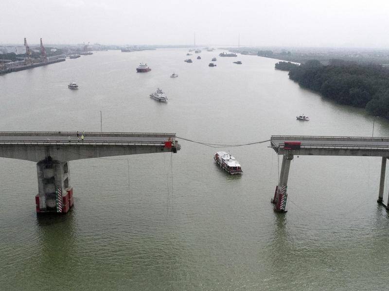 A barge has hit a bridge in China, plunging a bus and another vehicle into the water. (AP PHOTO)